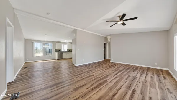 a view of empty room with wooden floor and window