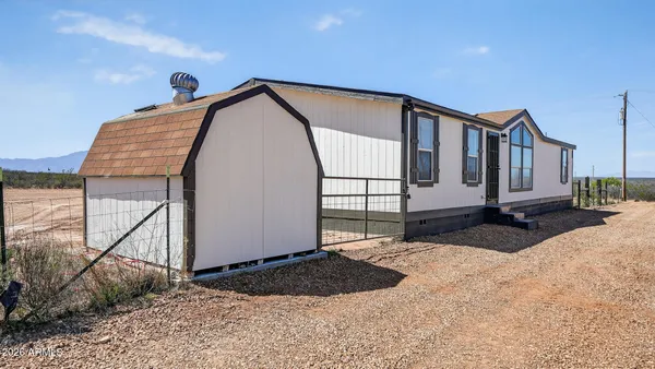 a view of a front of house with wooden fence