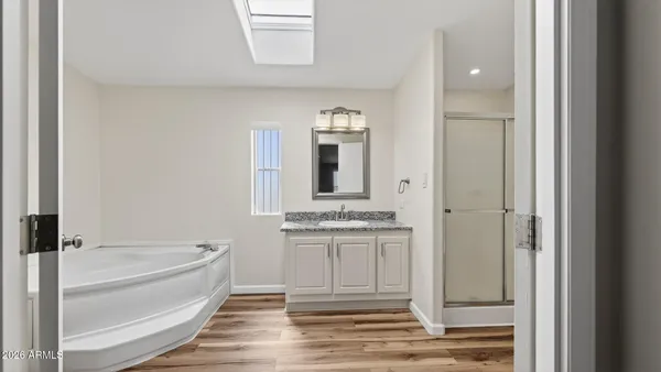 a bathroom with a granite countertop sink mirror and bathtub