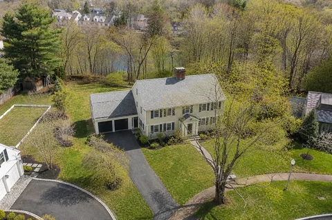 an aerial view of a house with a yard and street