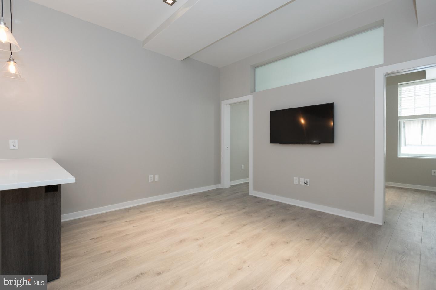 1602 Sansom Street, Unit 2 Philadelphia, PA 19103 - Photo 2 of 18 a view of an empty room with wooden floor and a window