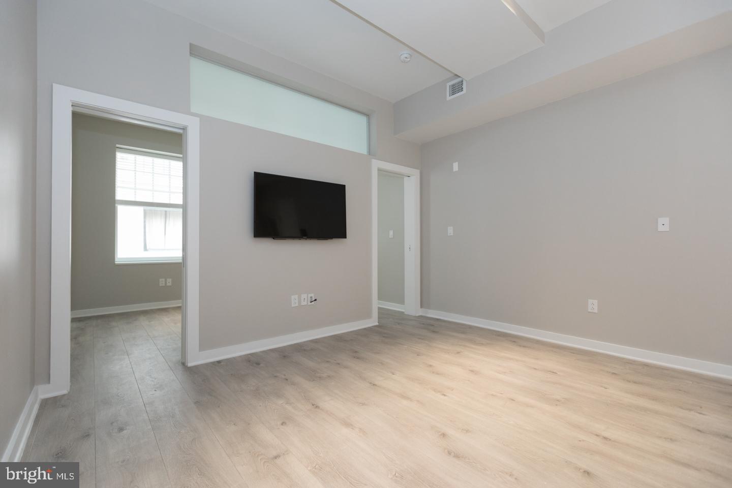 1602 Sansom Street, Unit 2 Philadelphia, PA 19103 - Photo 3 of 18 a view of an empty room with wooden floor and a window