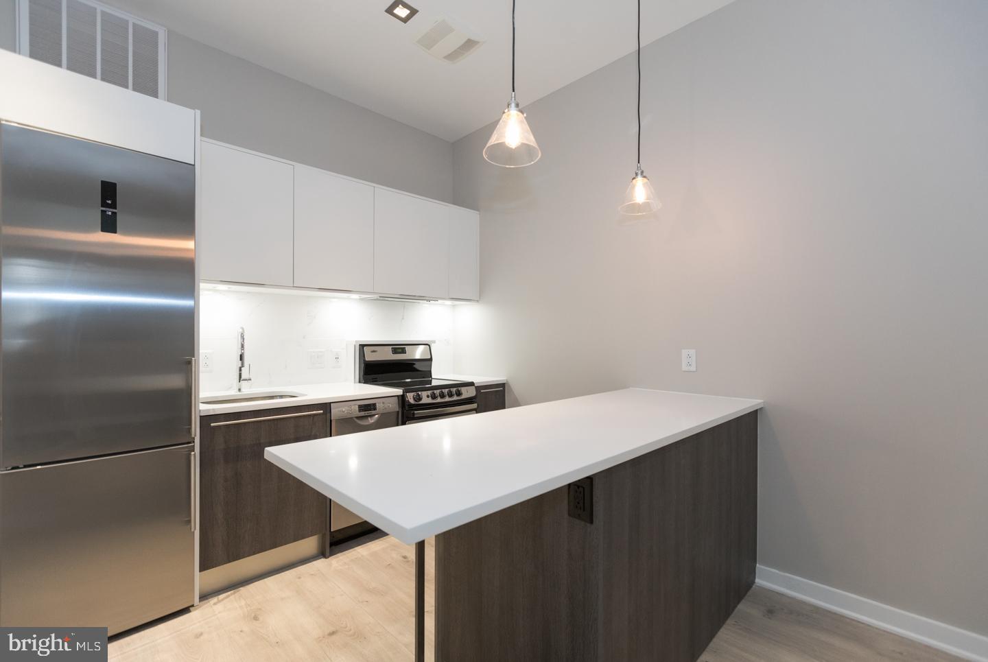 1602 Sansom Street, Unit 2 Philadelphia, PA 19103 - Photo 6 of 18 a kitchen with a sink a refrigerator and cabinets