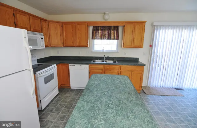 a kitchen with stainless steel appliances granite countertop a stove a sink dishwasher and a refrigerator