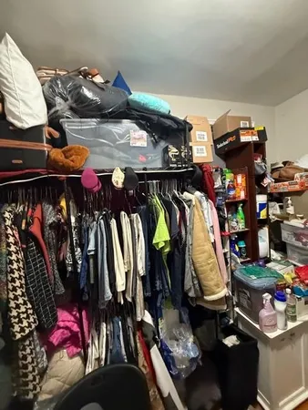 a view of walk in closet with clothes and shoes