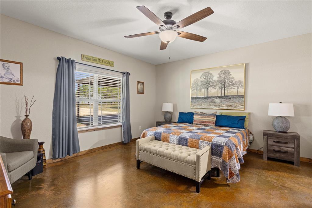 3761 County Road 149 Bluff Dale, TX 76433 - Photo 12 of 37 a bedroom with a bed painting on wall and a large window