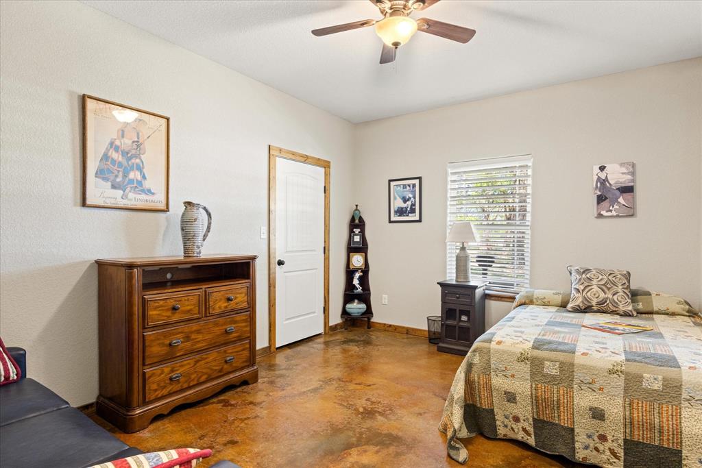 3761 County Road 149 Bluff Dale, TX 76433 - Photo 19 of 37 a bedroom with a bed and a chandelier
