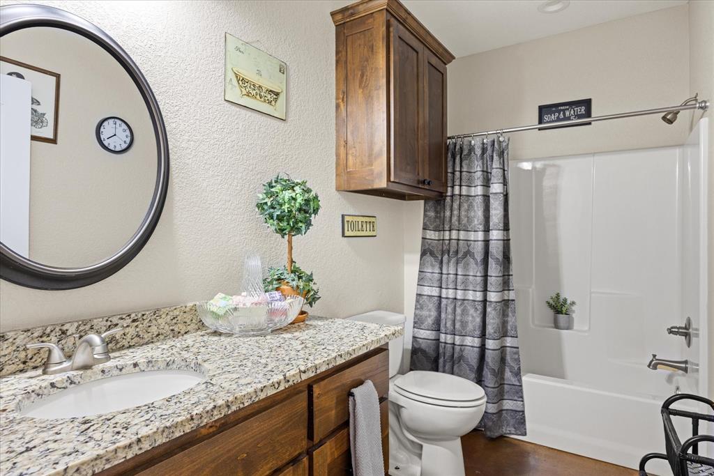 3761 County Road 149 Bluff Dale, TX 76433 - Photo 21 of 37 a bathroom with a granite countertop toilet sink and mirror