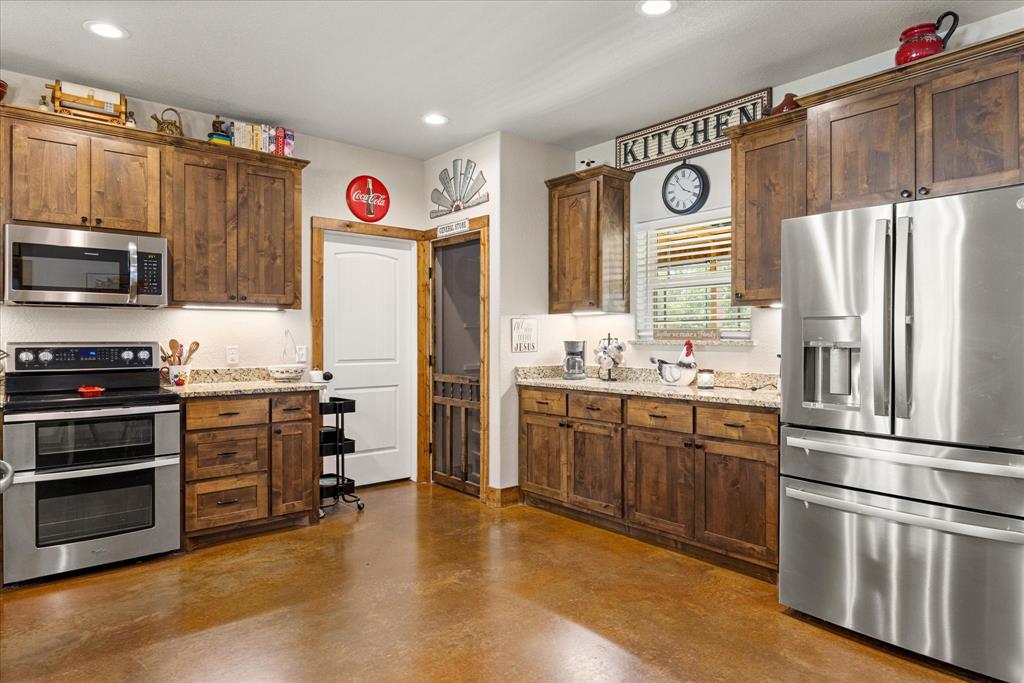 3761 County Road 149 Bluff Dale, TX 76433 - Photo 8 of 37 a kitchen with stainless steel appliances a refrigerator and a stove top oven