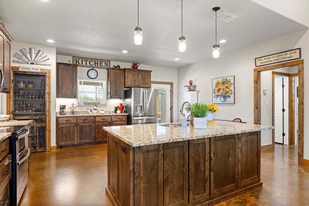 3761 County Road 149 Bluff Dale, TX 76433 - Photo 9 of 37 a kitchen with stainless steel appliances granite countertop a sink a stove and a wooden floors