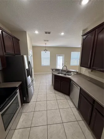 a kitchen with a sink a refrigerator and a stove top oven