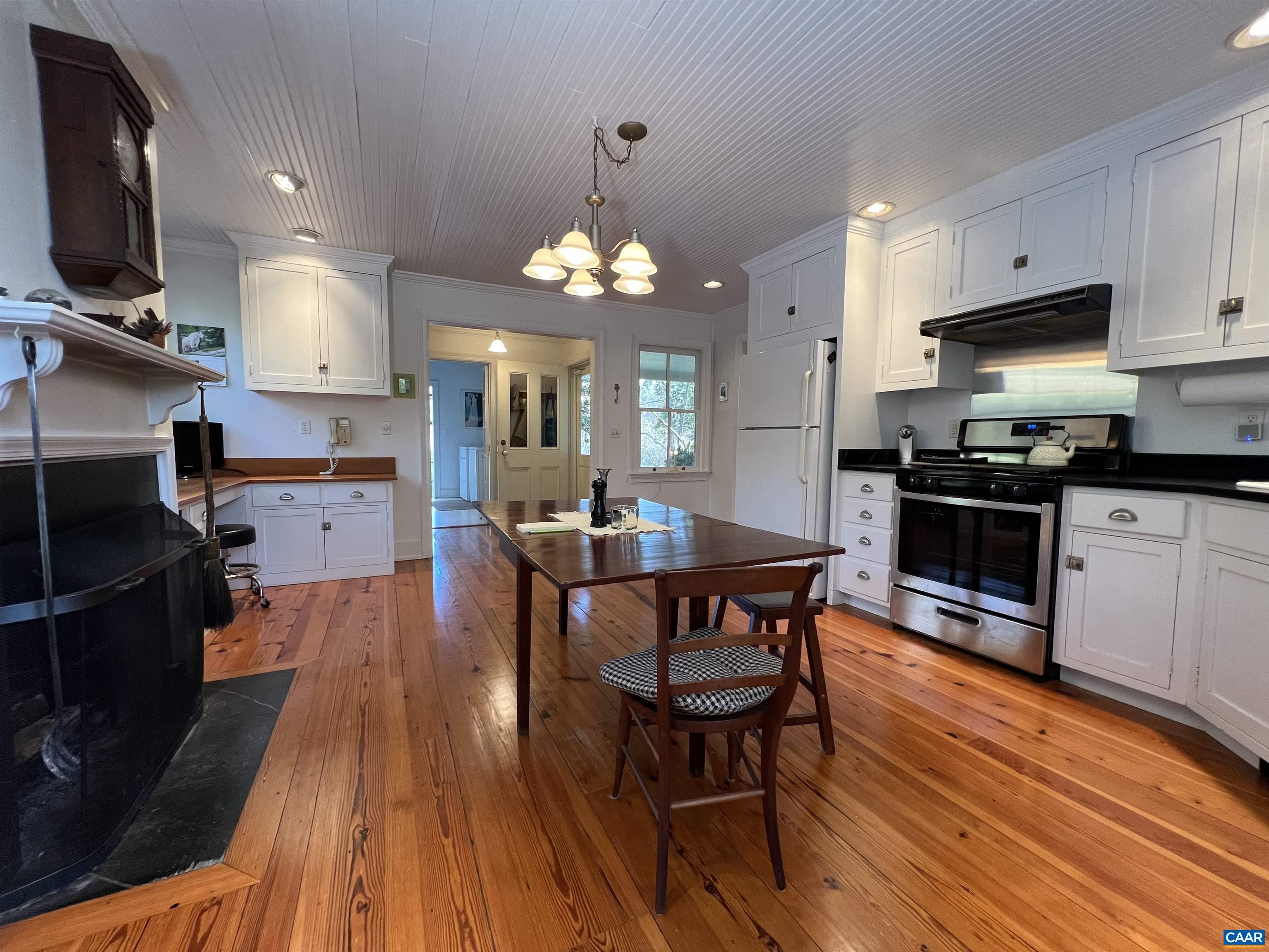 6742 Plank Road Charlottesville, VA 22903 - Photo 13 of 61 a kitchen with stainless steel appliances granite countertop a stove top oven a sink dishwasher a dining table and chairs with wooden floor