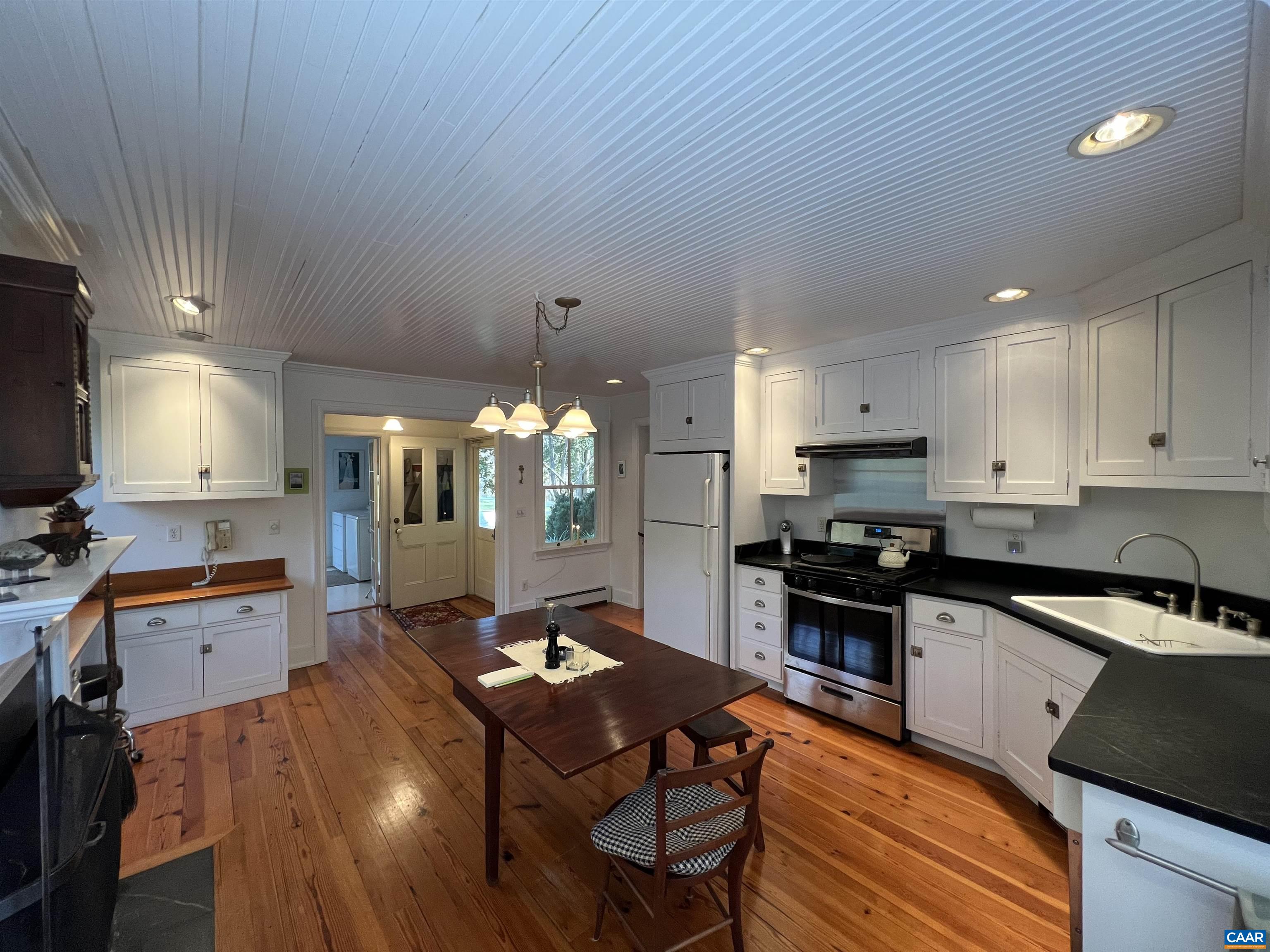 6742 Plank Road Charlottesville, VA 22903 - Photo 15 of 61 a kitchen with stainless steel appliances granite countertop a stove top oven a sink dishwasher a dining table and chairs with wooden floor