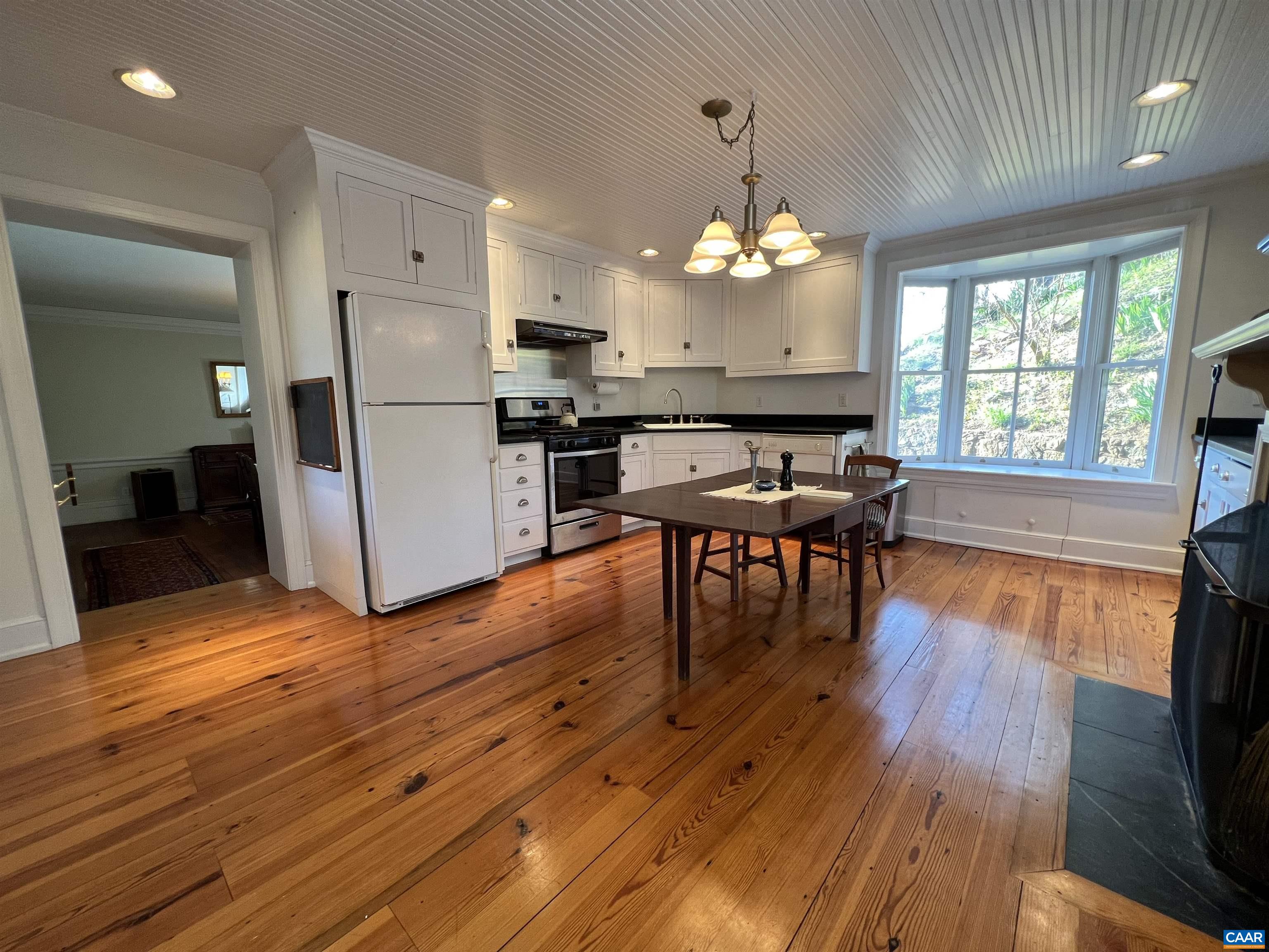 6742 Plank Road Charlottesville, VA 22903 - Photo 17 of 61 a view of a dining room with furniture a chandelier and wooden floor