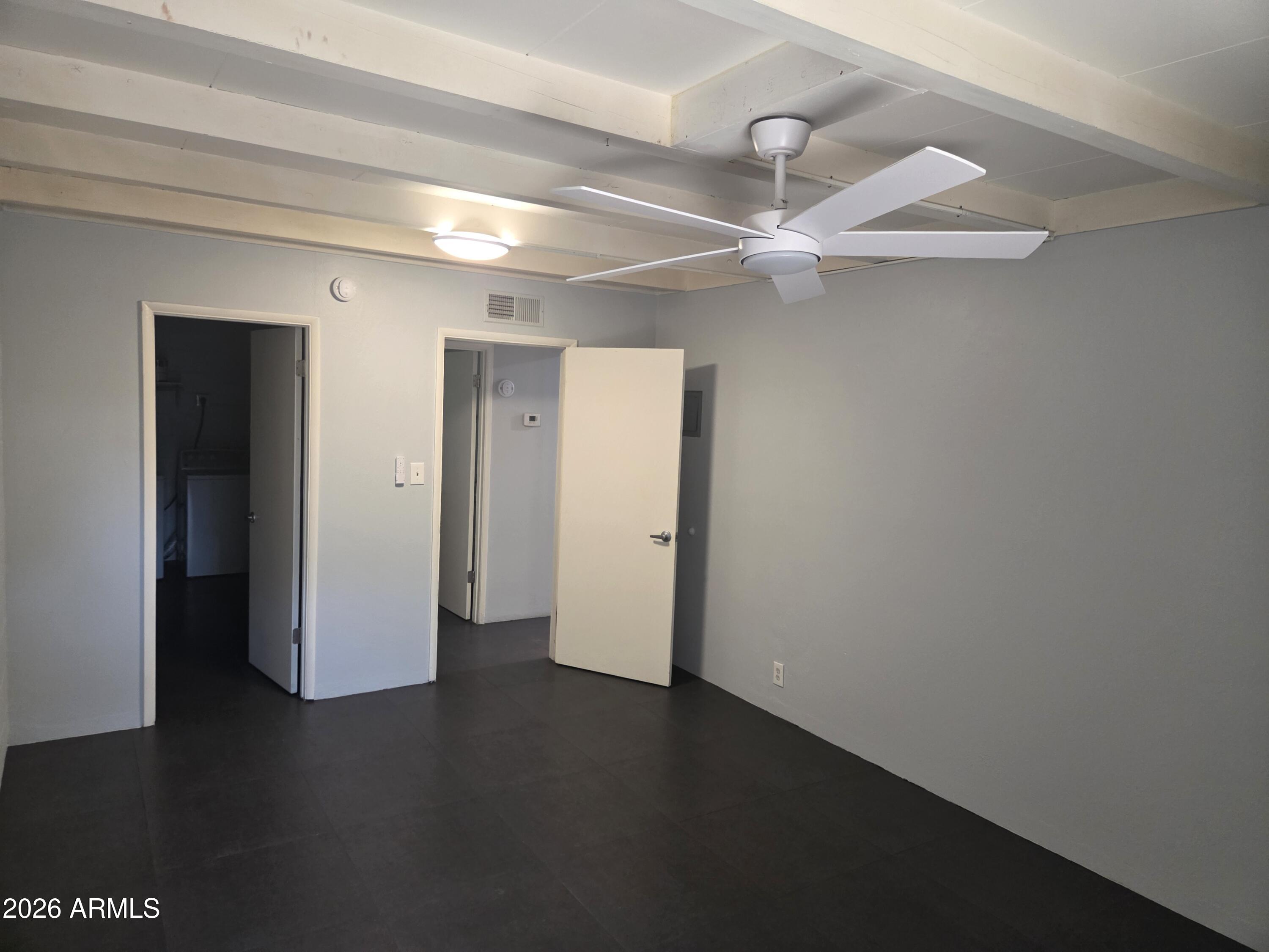 1101 East Bethany Home Road, Unit 7 Phoenix, AZ 85014 - Photo 8 of 14 an empty room with wooden floor and a ceiling fan