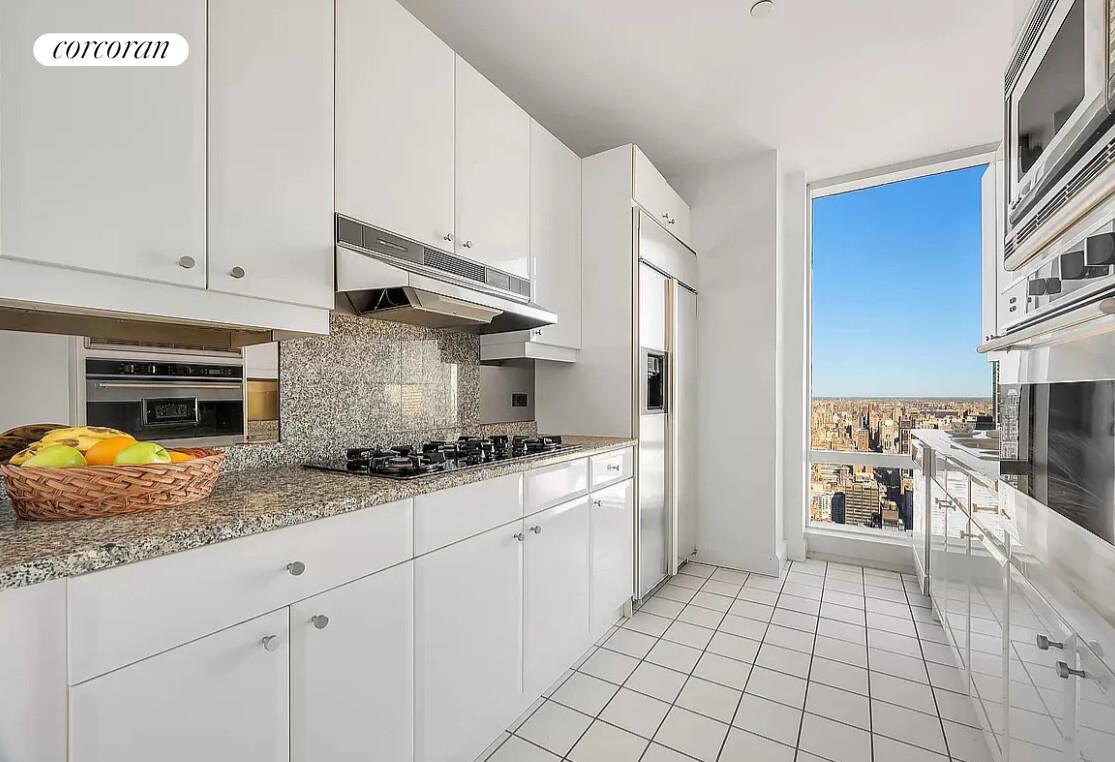 845 United Nations Plaza, Unit 42E Manhattan, NY 10017 - Photo 5 of 10 a kitchen with stainless steel appliances granite countertop a stove a sink and a refrigerator