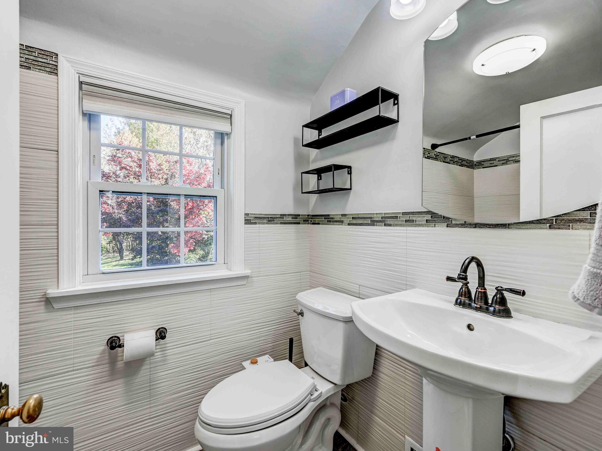 913 Adana Road Baltimore, MD 21208 - Photo 15 of 26 a bathroom with a sink a mirror and a toilet