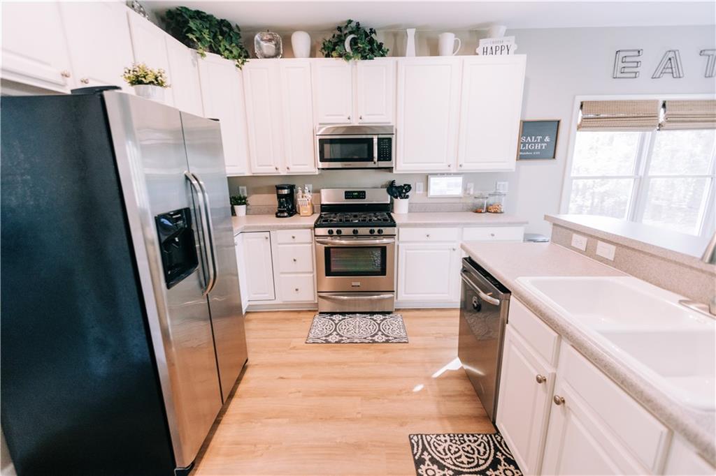 2533 Gold Hill Court Villa Rica, GA 30180 - Photo 11 of 50 a kitchen with a sink a microwave a refrigerator and cabinets