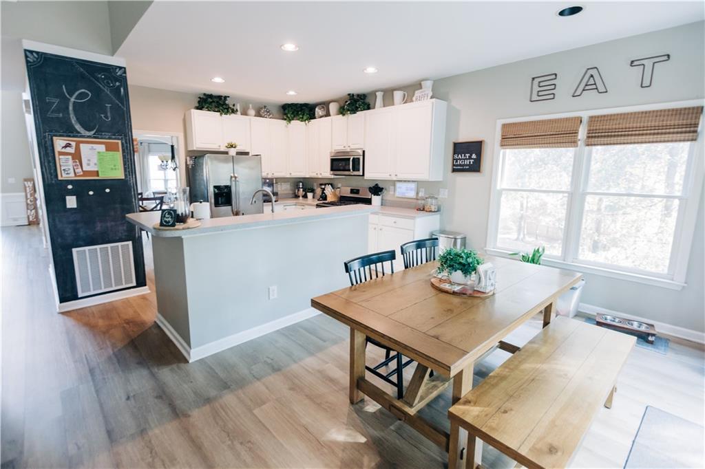 2533 Gold Hill Court Villa Rica, GA 30180 - Photo 10 of 50 a kitchen with stainless steel appliances granite countertop a refrigerator a stove top oven a sink dishwasher and white cabinets with wooden floor