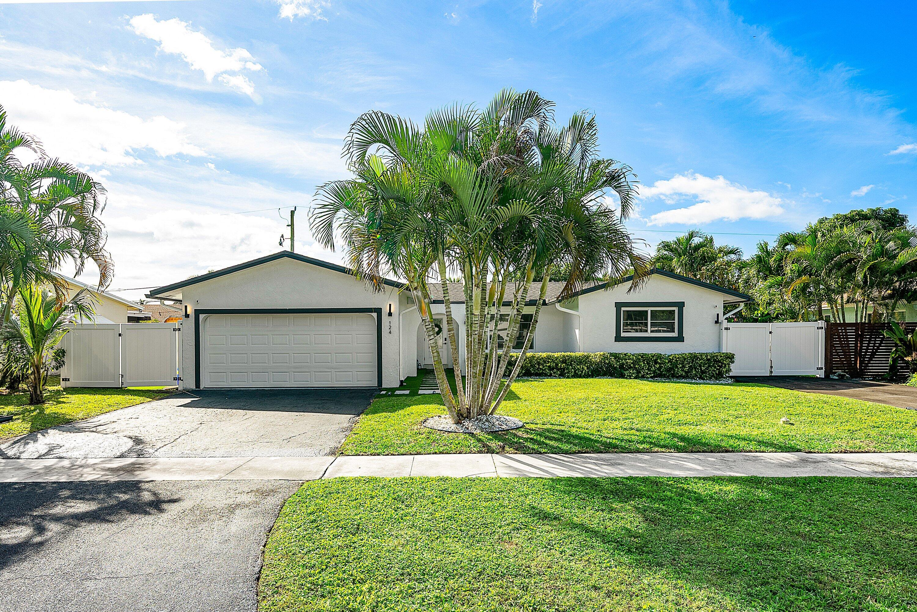 124 Oregon Lane Boca Raton, FL 33487 - Photo 1 of 41 a front view of a house with a yard and garage