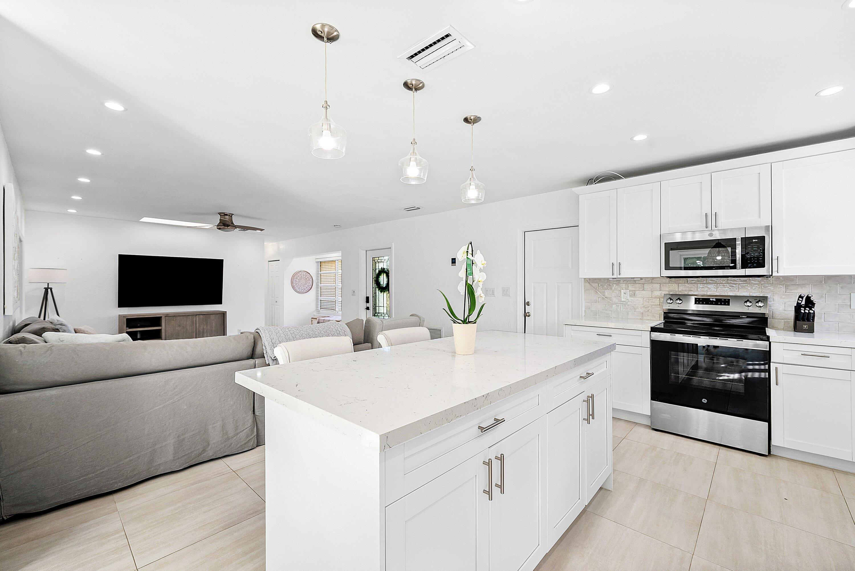124 Oregon Lane Boca Raton, FL 33487 - Photo 11 of 41 a kitchen with stainless steel appliances a stove refrigerator sink and microwave