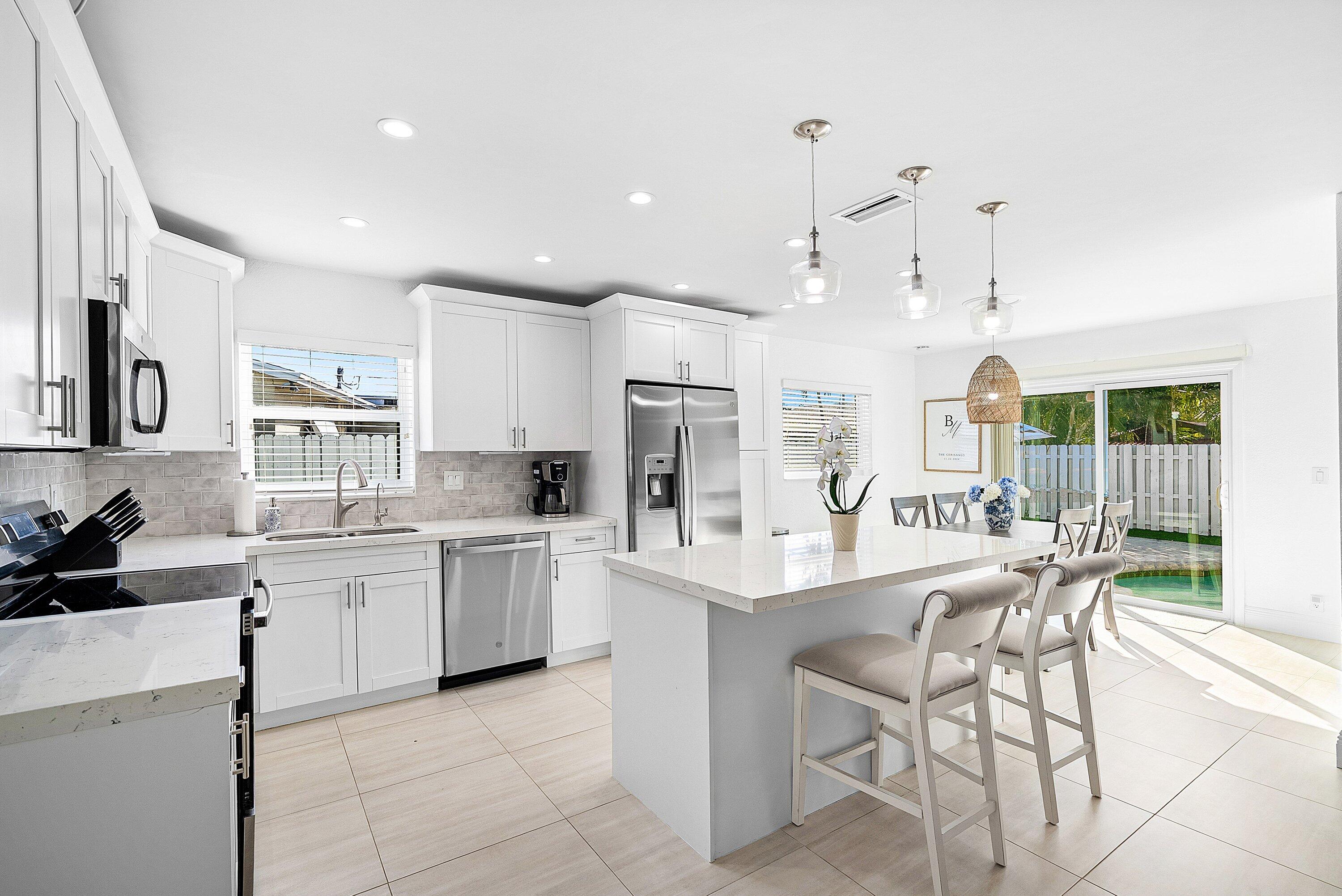 124 Oregon Lane Boca Raton, FL 33487 - Photo 5 of 41 a large kitchen with kitchen island wooden cabinets and stainless steel appliances