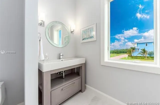 a bedroom with a bed painting and a large window