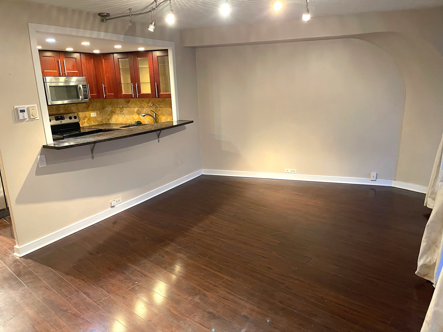 300 North State Street, Unit 2427 Chicago, IL 60654 - Photo 4 of 9 an empty room with wooden floor and windows