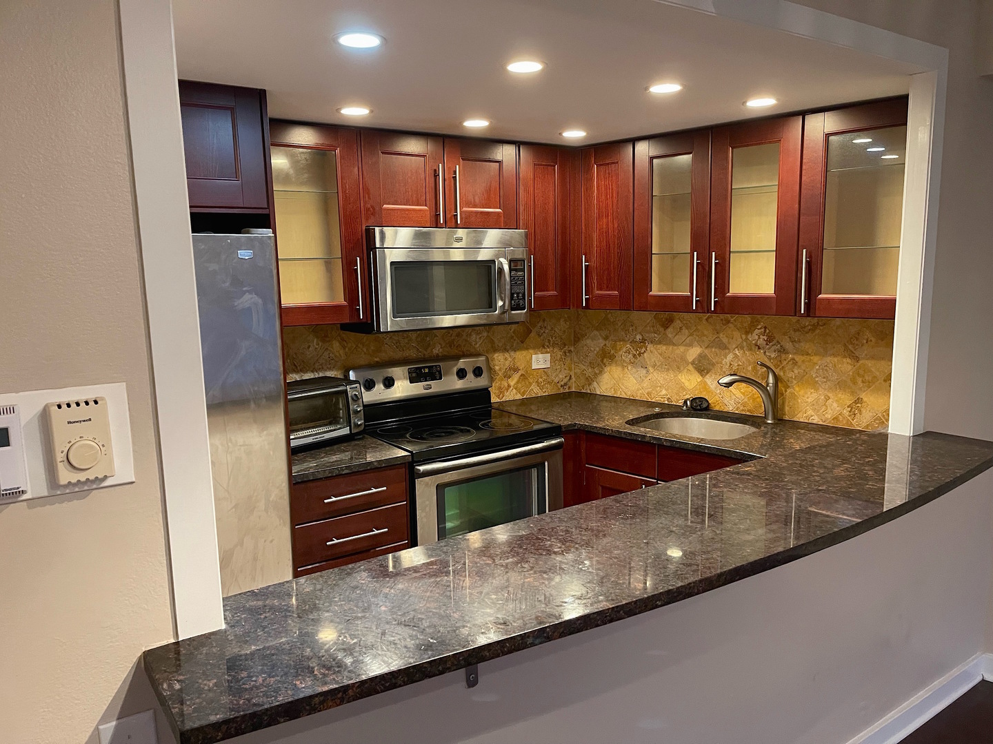 300 North State Street, Unit 2427 Chicago, IL 60654 - Photo 5 of 9 a kitchen with stainless steel appliances granite countertop a sink a stove and a refrigerator with wooden floor