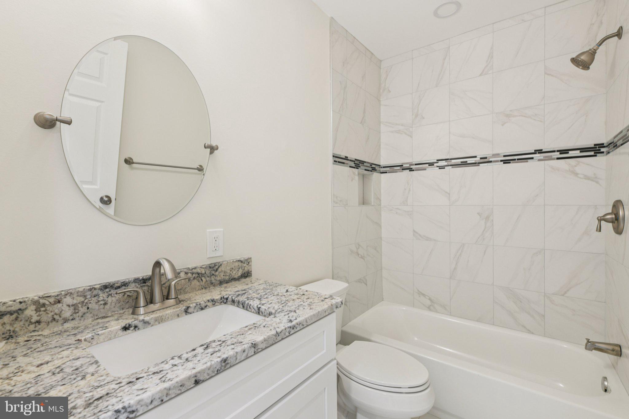 729 Madison Street Northwest Washington, DC 20011 - Photo 18 of 59 a bathroom with a granite countertop sink a toilet and a mirror