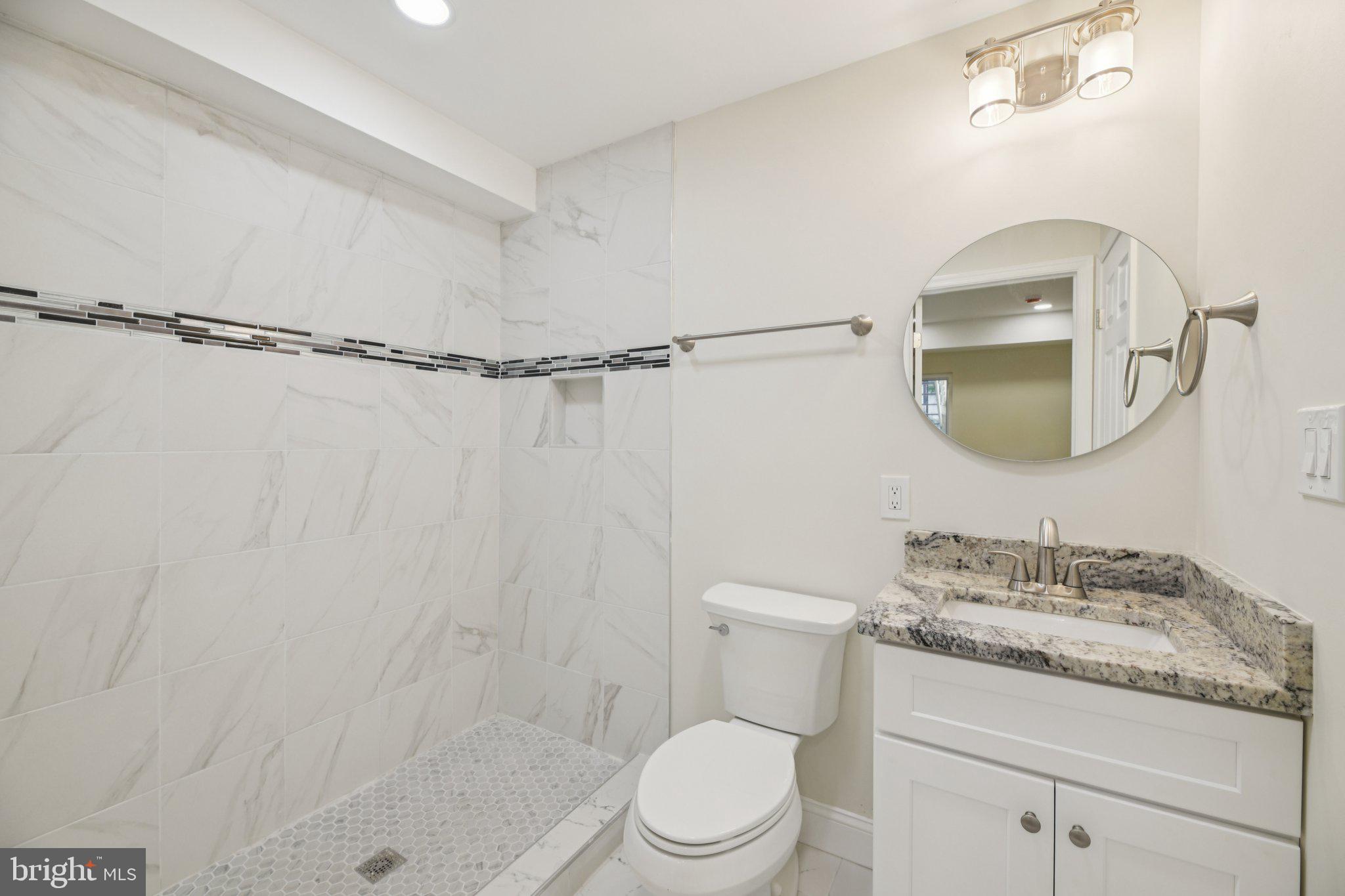 729 Madison Street Northwest Washington, DC 20011 - Photo 42 of 59 a bathroom with a granite countertop sink mirror vanity and toilet