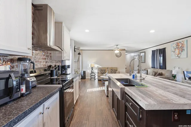 a kitchen with counter top space a sink stove and cabinets