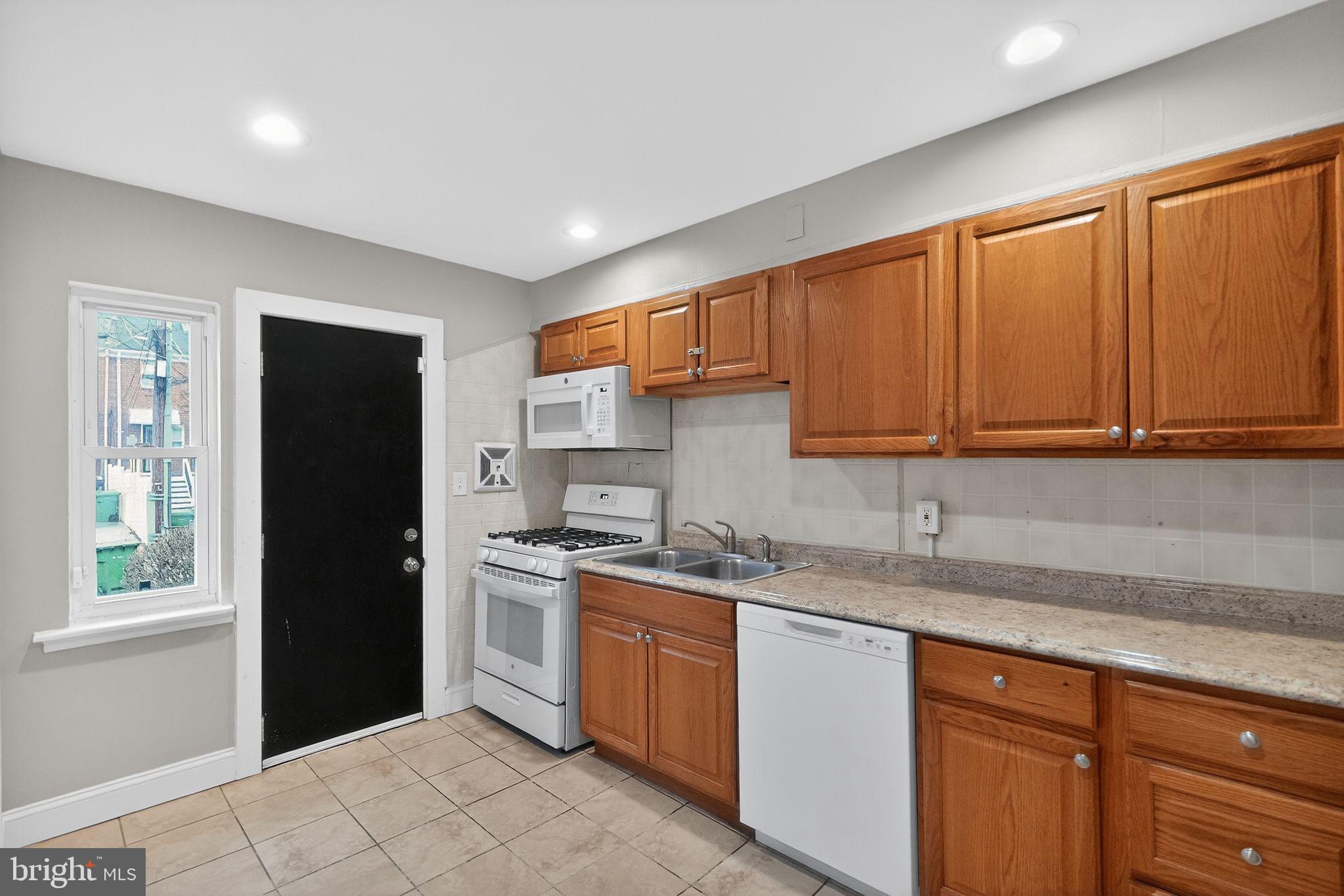 2018 Winford Road Baltimore, MD 21239 - Photo 8 of 29 a kitchen with a sink dishwasher stove and refrigerator