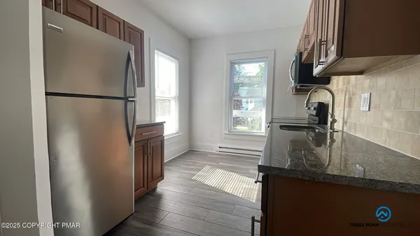 a kitchen with granite countertop a refrigerator and a sink