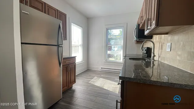 a kitchen with granite countertop a refrigerator and a sink