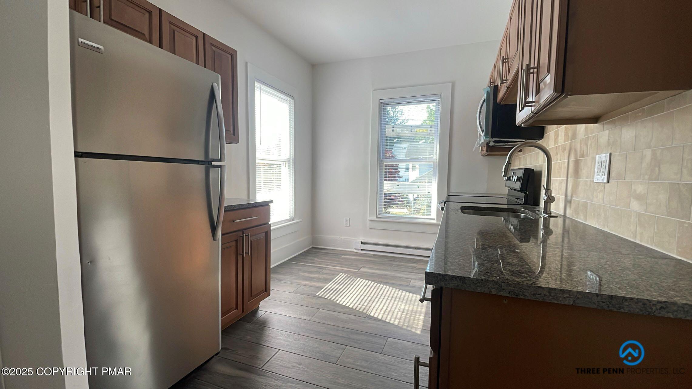 100 Broad Street, Unit B Stroudsburg, PA 18360 - Photo 6 of 18 a kitchen with granite countertop a refrigerator and a sink