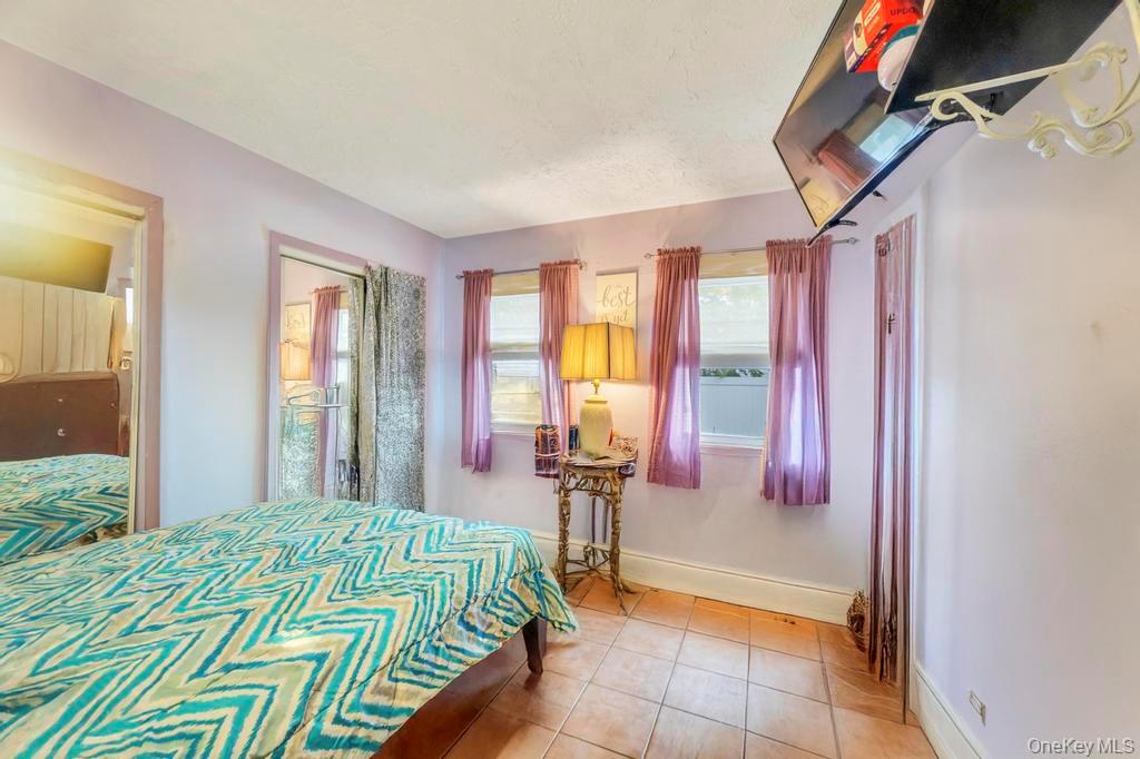 182 Commack Road Deer Park, NY 11729 - Photo 19 of 24 a bedroom with a bed and a chandelier