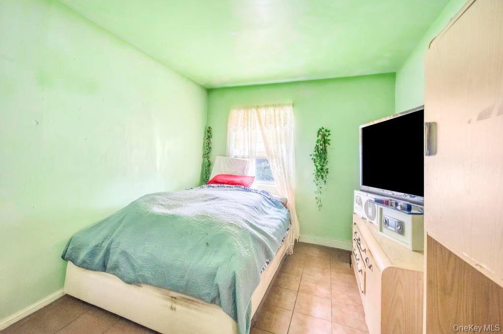 182 Commack Road Deer Park, NY 11729 - Photo 23 of 24 a bedroom with a bed and a flat screen tv