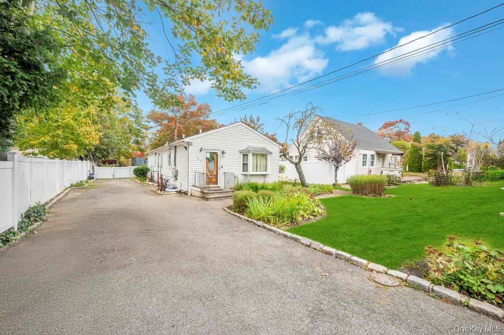 182 Commack Road Deer Park, NY 11729 - Photo 3 of 24 a view of house with garden and tall trees