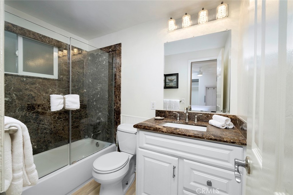 4005 Seashore Drive Newport Beach, CA 92663 - Photo 11 of 32 a bathroom with a granite countertop sink a toilet a mirror and shower