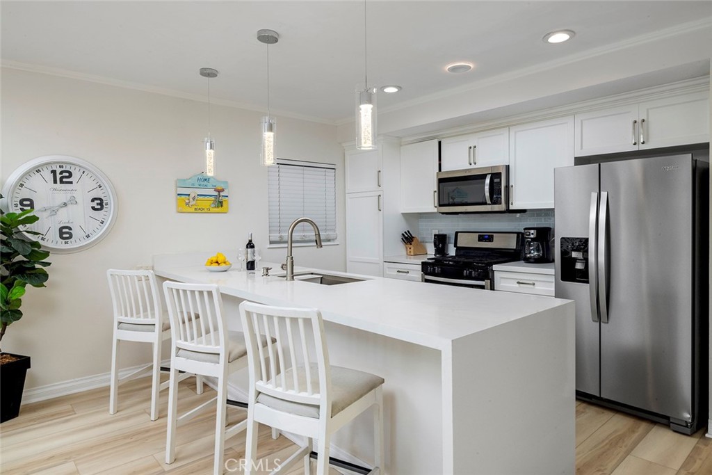 4005 Seashore Drive Newport Beach, CA 92663 - Photo 6 of 32 a kitchen with kitchen island wooden cabinets and refrigerator