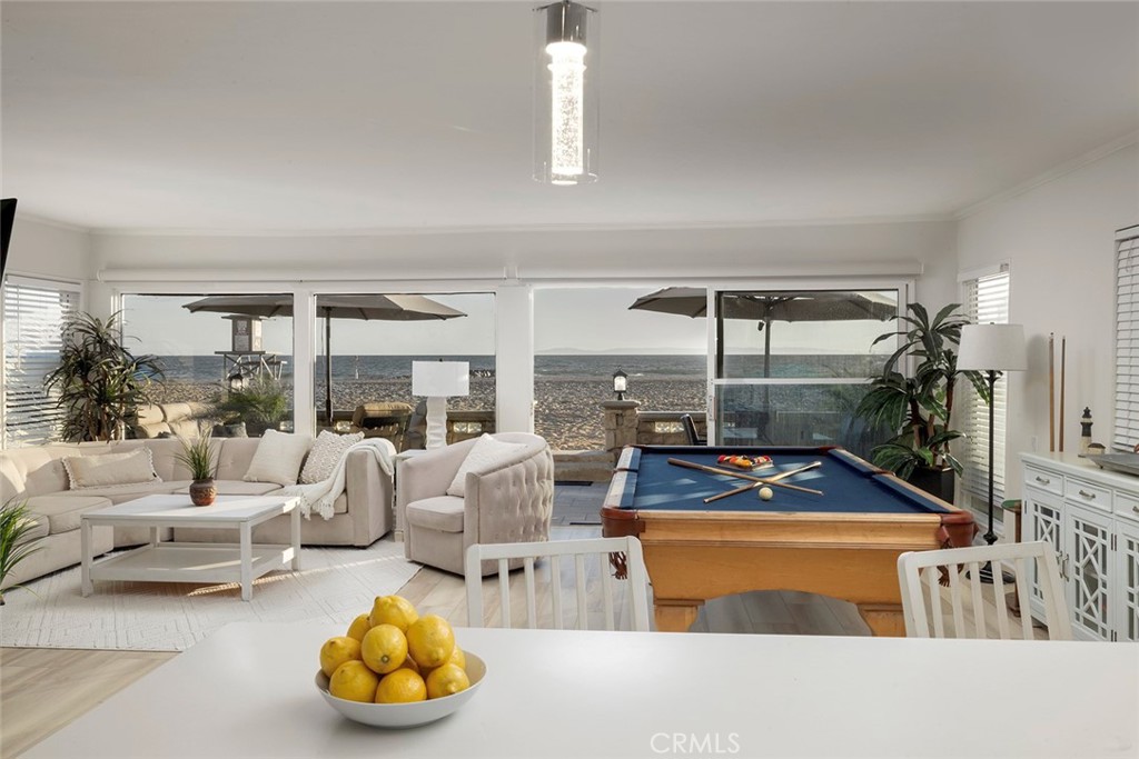 4005 Seashore Drive Newport Beach, CA 92663 - Photo 7 of 32 a living room with furniture a chandelier and a floor to ceiling window