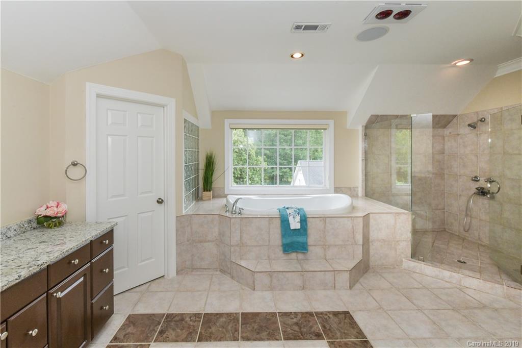 919 Colville Road Charlotte, NC 28207 - Photo 14 of 38 a spacious bathroom with a granite countertop sink a bathtub and next to a window