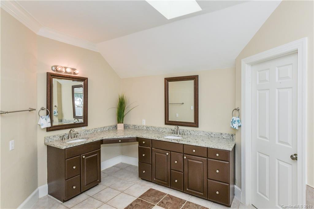 919 Colville Road Charlotte, NC 28207 - Photo 15 of 38 a spacious bathroom with a granite countertop double vanity sink and a mirror