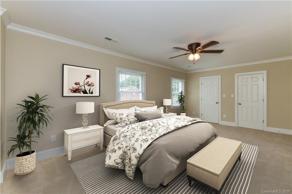 919 Colville Road Charlotte, NC 28207 - Photo 16 of 38 a bedroom with a large bed a couch and potted plant