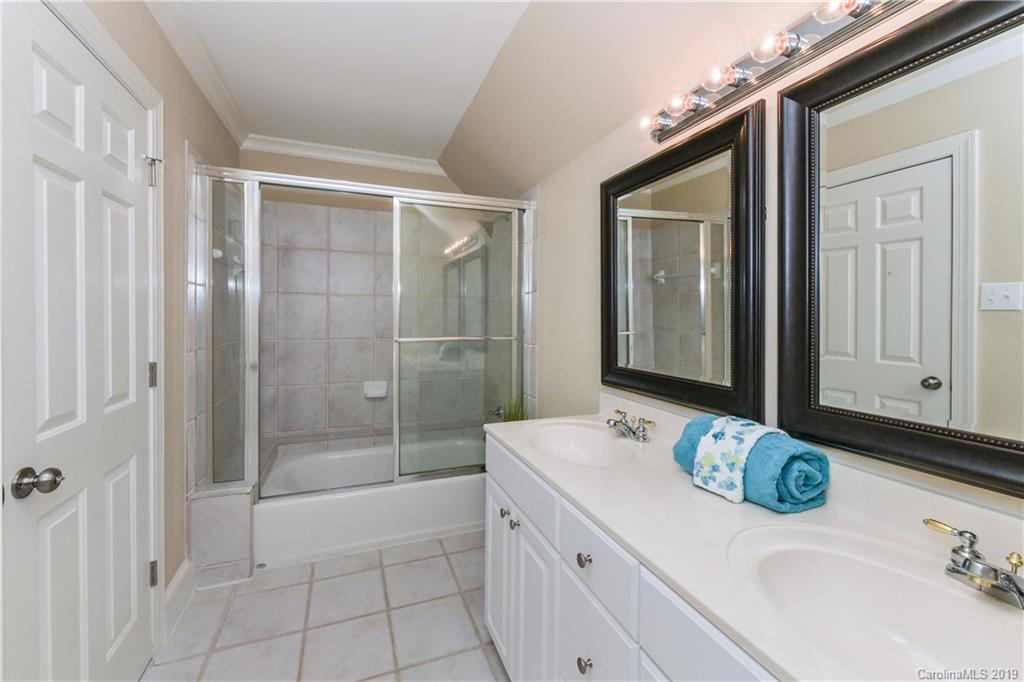 919 Colville Road Charlotte, NC 28207 - Photo 17 of 38 a bathroom with a granite countertop sink a mirror and shower