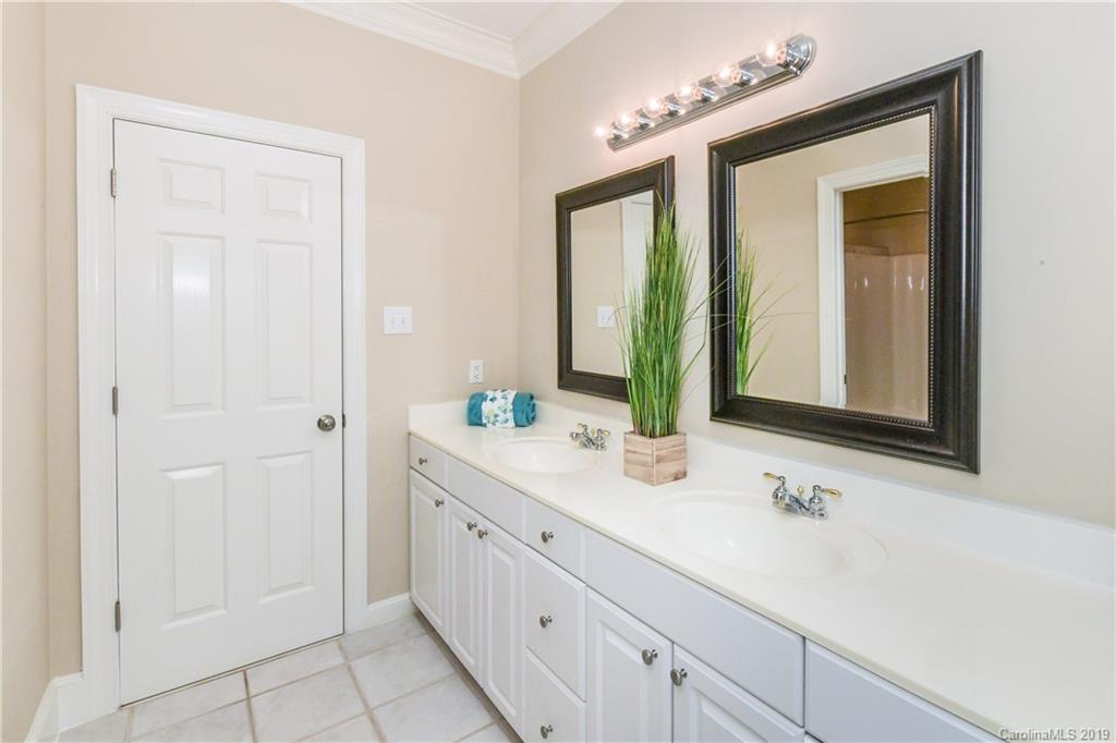 919 Colville Road Charlotte, NC 28207 - Photo 19 of 38 a bathroom with a double vanity sink and a mirror