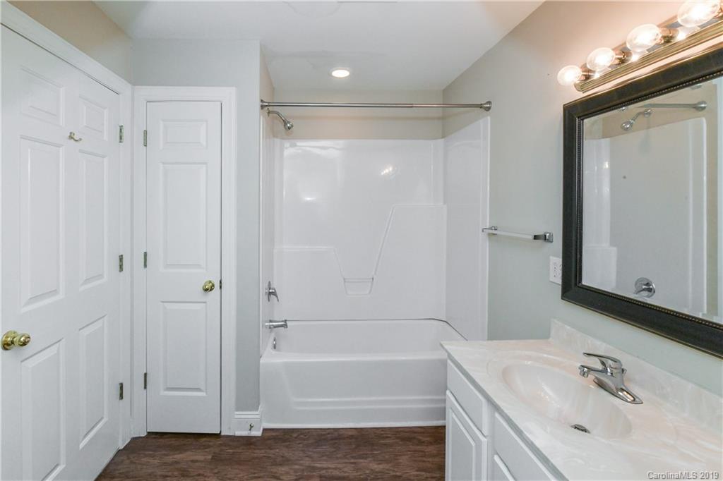 919 Colville Road Charlotte, NC 28207 - Photo 32 of 38 a bathroom with a tub shower vanity and a sink