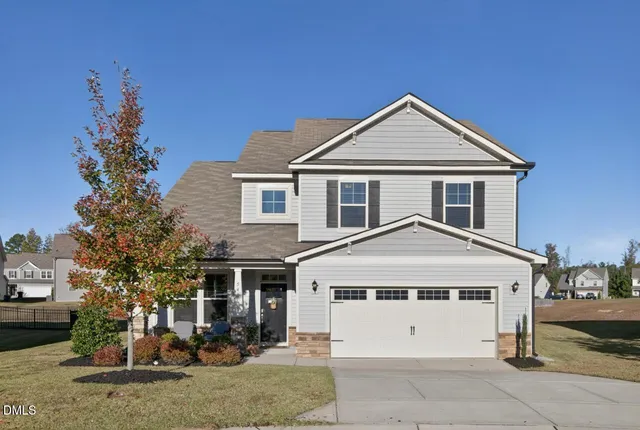 a view of a white house with a large windows yard and palm trees