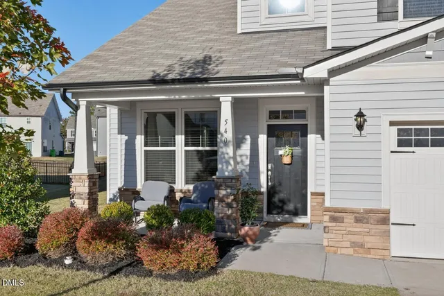 a front view of a house with a lots of potted plants